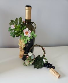 a bottle of wine and some flowers on a table