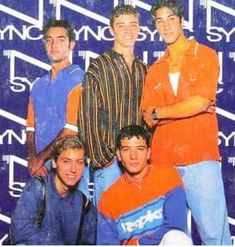 four young men posing for a photo in front of a blue and white background