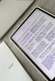 an open tablet computer sitting on top of a table next to a laptop keyboard and mouse