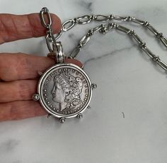 This bold coin makes a great statement piece that can be dressed up or down.  The reproduction US silver dollar hangs from a mixed link cable chain with a rhodium finish.  Rhodium is a metal that, when used as a plating, enhances the durability, is scratch resistant, and will not tarnish.   No nickel, cadmium, or lead is ever used in my jewelry. Coin Necklace Silver, Silver Coin Necklace, Bracelets Silver, Jewelry Bracelets Silver, Medallion Necklace, Coin Jewelry, Silver Dollar, Coin Necklace, Necklace Vintage