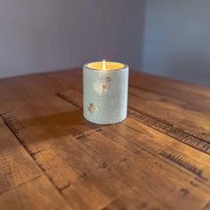 a lit candle sitting on top of a wooden table