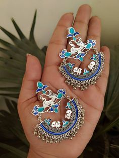 "Add charm and charisma to your beautiful personality with these exquisitely handcrafted Afghani earrings made with high quality German Silver. The intricate design and the glass enamel work renders these earrings a very unique and classy look. Pair them up with any formal or casual attire and gather compliments all the way! Weight 25gm Length 2.8\" Width 1.8\"" Silver Bohemian Jewelry With Meenakari, Bohemian Silver Jewelry With Meenakari, Traditional Artistic Design Drop Earrings, Silver Meenakari Chandelier Earrings For Festivals, Traditional Enamel Jewelry With Matching Earrings, Handmade Enamel Earrings For Wedding, Metal Chandbali Danglers With Meenakari, Silver Chandbalis With Peacock Design For Festivals, Metal Meenakari Chandbali Danglers