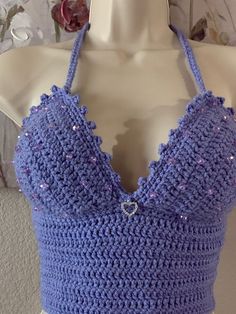 a crocheted top is displayed on a mannequin