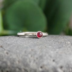 Garnet symbolizes love and is the gemstone to give for the 2nd anniversary. It is also the birthstone for January. This simple sterling silver stacking ring is a great gift, or an addition to a collection of stacking rings. Here are the details: This ring is made with a 4mm or 5-6mm bezel set garnet cabochon set on a sturdy sterling silver band handmade in your size. It can be worn with other stackable rings, or by itself.Please select your ring size. Sizes are US based. Red Birthstone Ring With Bezel Setting In Sterling Silver, Stackable Sterling Silver Ruby Ring, Red Garnet Stackable Rings, Silver Garnet Rings With Bezel Setting, Red Garnet Ring Sterling Silver, Corvallis Oregon, Plain Silver Rings, Sea Glass Ring, Rings Sterling Silver