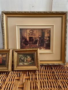 three framed pictures sitting on top of a wicker table