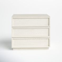 a white dresser with three drawers on it