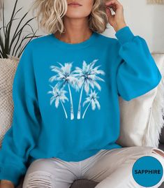 🌴Palm Tree crewneck sweatshirt!🌴 This Trendy Palm Tree sweater in a watercolor graphic is super soft and comfortable. Perfect as an oversized beach cover up or for a casual day out. Looks super cute with jeans or shorts. Makes a nice gift for Mother's Day, a Birthday or a Palm Tree lover! Comes in 9 pretty colors.🏝️ ✨PRINT: This is a handmade, Direct-to-Garment printed item. The designs are professionally printed directly on to the shirt. All over printing is used. The ink is printed directly Trendy Blue Summer Sweatshirt, Trendy Blue Sweatshirt For Summer, Trendy Printed Crew Neck Sweatshirt, Blue Crew Neck Sweatshirt For Beach Season, Spring Crew Neck T-shirt With Palm Tree Print, Summer Beach Long Sleeve Sweatshirt, Blue Crew Neck Sweatshirt For Summer, Casual Long Sleeve T-shirt For Vacation, Blue Relaxed Fit Sweatshirt For Beach Season