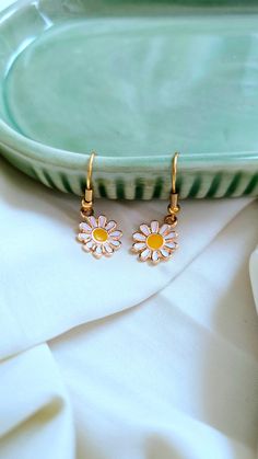 Add a touch of whimsy to your outfit with our Daisy Earrings. These adorable daisies will bring a smile to your face and brighten up any look. Perfect for adding a playful touch to your style. 🌼 Earring Details: White daisies Gold furnishings Dainty Adjustable Flower Earrings For Spring, Dainty White Earrings For Spring, Whimsical Spring Flower Earrings With Ear Wire, White Flower-shaped Trendy Earrings, Trendy White Flower-shaped Earrings, White Earrings With Ear Wire For Spring, Whimsical Spring Earrings For Pierced Ears, Spring White Earrings With Ear Wire, Whimsical Spring Earrings With Flower Charm