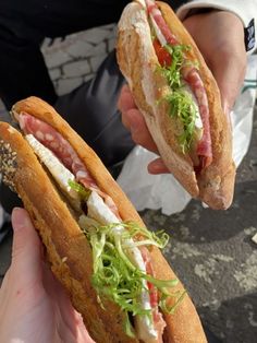 two people holding sandwiches in their hands with meat and veggies on them,