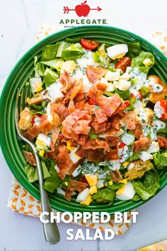 a green plate topped with salad next to a fork