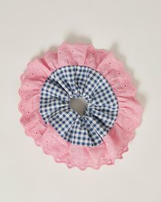 Indulge in sustainable style with this unique, handmade scrunchie. Crafted from repurposed materials, this accessory is not only kind to the planet but also a statement piece. The intricate broderie anglaise trim in pink teamed with the navy gingham cotton make it a true one-of-a-kind find. Whether you're dressing up or keeping it casual, this scrunchie adds a touch of individuality to your look. Embrace eco-fashion and elevate your hair game with this handcrafted treasure. Handmade with love by Upcycled Hair Accessories, Handmade Scrunchie, Board Display, Navy Gingham, Event Gifts, Pink Trim, Sustainable Style, The Navy, Sewing Gifts