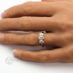 a woman's hand with a diamond ring on top of her left hand,