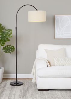 a living room with a white couch and a black floor lamp