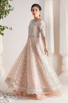 Step up your festive dressing game with our beautifully crafted kalidar over a canvas of stunning embroidered organza, heavily embellished with sequins, beads, crystals, neckline and sleeves beautifully adorned with gorgeous zardozi, mirror work & Resham thread work. Stunning hand-made stylized tassel details at back. This stunning multi panel kalidar is offset with jamawar Lehanga with gorgeous ruffle details & net dupatta featuring sequins & mirror motifs and chan, trimmed with mirror embroidered borders , a Must- have wardrobe staple to carry all Wedding Festivities in effortless style. Shirt Fabric: Pure embroidered Organza & Silk Net Lehanga Fabric: Jamawar Dupatta Fabric: French Net Color: Shell Pink This outfit is only available in Custom size, once order is placed design team will Elegant Embellished Embroidered Fabric For Festive Season, Reception Anarkali Set With Dabka Work For Navratri, Eid Anarkali Hand-embellished Sets, Embellished Raw Silk Anarkali Kurta, Eid Hand Embellished Organza Salwar Kameez, Embroidered And Embellished Fabric For Designer Wear During Navratri, Designer Hand Embellished Organza Salwar Kameez, Designer Hand-embellished Organza Salwar Kameez, Embellished Organza Anarkali Saree