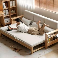 a woman laying on top of a white couch next to a table with a laptop