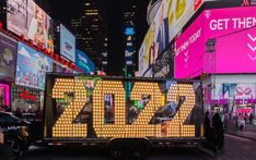 a man standing in front of a large sign on the back of a truck at night