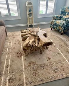 a living room filled with furniture and a large wooden table on top of a rug