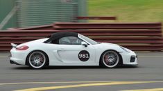 a white sports car driving down a race track