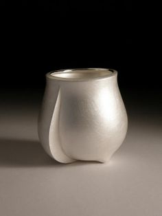 a white vase sitting on top of a table