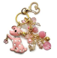 a pink and white keychain with lots of charms on it's side