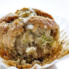 a muffin in a paper cup on a white surface