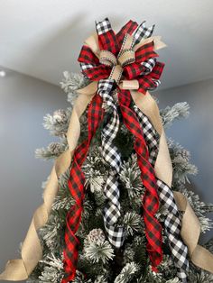 a christmas tree decorated with plaid ribbon and bows