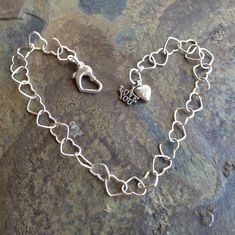 She will definitely be feeling the love with this charming bracelet!  Sterling silver hearts link together to form a delicate chain bracelet.   Finished with a sturdy heart-shaped lobster clasp and a dangling duo of charms.  This comes in two lengths: 8 in. and 8 1/2 in..  The clasp can attach to any of the links to fine-tune the fit.  Made with love, of course! Sterling Silver Heart Charm Bracelet For Everyday, Sterling Silver Heart Bracelet For Mother's Day And Friendship, Silver Heart Charm Bracelet For Friendship, Sterling Silver Bracelets With Heart Charm For Friendship, Nickel Free Heart Charm Bracelet For Friendship, Heart Shaped Nickel Free Friendship Charm Bracelet, Sterling Silver Heart Bracelet For Everyday, Sterling Silver Double Heart Bracelet For Everyday Wear, Sterling Silver Everyday Charm Bracelet For Mother's Day