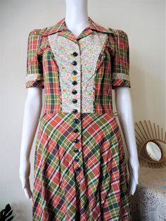 Stunning True Vintage Betty Barclay prairie dress from the 1970s or early 1980s. Made from comfortable cotton fabric in a patchwork inspired style: madras check interchanging with florals and green trims. Maxi length, fitted top, wide skirt. Button front bib, puff sleeves, belt loops, ruffle hem. Unlined. Looks great with a pair of clogs and a wicker bag! ERA: 1970s, 1980s BRAND: Betty Barclay COLOR: Red, green, off-white, pink, orange FABRIC; No fabric tag, very likely pure cotton SIZE: No size Vintage Patchwork Dresses For Daywear, Vintage Patchwork Daywear Dresses, Fitted Plaid Vintage Dress, Retro Gingham Cotton Vintage Dress, Retro Gingham Vintage Dress In Cotton, Retro Gingham Vintage Cotton Dress, Retro Cotton Vintage Dress For Fall, Retro Patchwork Short Sleeve Dresses, Retro Short Sleeve Patchwork Dress