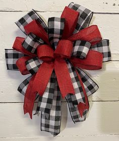 a black and white checkered bow with red ribbon on the front of a door