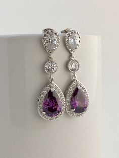 Luxury purple amethyst cubic zirconia bridal teardrop earrings in rhodium plated brass setting. I've created these luxurious earrings using a large teardrop with pear cut purple amethyst cubic zirconia center surrounded by tiny round zirconia crystals. Teardrop dangles from a clear cubic zirconia ear stud and a round cubic zirconia connector. Total length of the earring is 4.6 cms. For matching necklace click: https://www.etsy.com/listing/465785454/purple-amethyst-cubic-zirconia-bridal?ref=listi Luxurious Earrings, Purple Drop Earrings, Drop Earrings Wedding, Luxury Purple, Purple Dangle Earrings, Teardrop Bridal Earrings, Black Crystal Earrings, Pink Pearl Earrings, Lavender Earrings