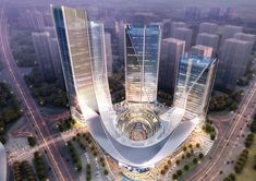 an aerial view of two tall buildings in the middle of a city with traffic and street lights