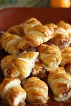 several croissants on a plate with oranges in the background