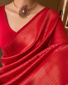 a red sari draped over a mannequin with a gold necklace on it