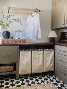 a kitchen with white cabinets and black and white checkered flooring on the floor