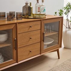 a wooden cabinet with glass doors and dishes on top