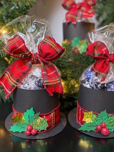 two hats with candy in them sitting on a table next to christmas decorations and wreaths