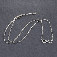 Centered between the two lengths of shiny silver tone chain, this miniature eternity symbol appears to float along the neck. Completely encrusted in micro CZ stones creating incredible shimmer. At only 2 cm this is truly subtle and graceful. This necklace is perfect for women, teens or young children. Length: 18 inch chain Stones: CZ Metal: Sterling Silver, 3 layers of platinum plating. Comes in a gift box. (Reg $45.99) Infinity Symbol Necklace, Eternity Symbol, Infinity Symbol, Micro Pave, Shiny Silver, Cz Stone, Sterling Silver Necklaces, Womens Necklaces, Platinum