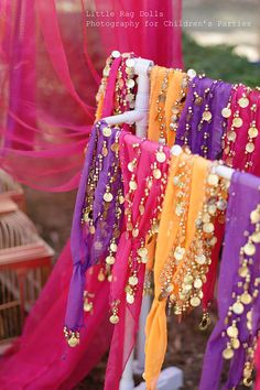 an assortment of colorful scarves hanging from a rack