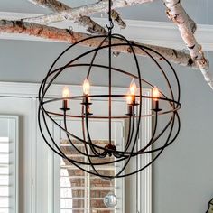 a chandelier hanging from the ceiling in a room with white walls and windows