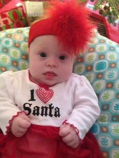 a baby with red hair sitting in a chair