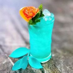 a blue cocktail with an orange flower on top