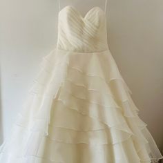 a white wedding dress hanging on a hanger