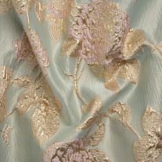 the fabric has gold and pink flowers on it, as well as some other things