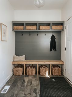 a bench with baskets and coat hooks on it