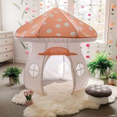 a pink and white tent with polka dots on it in a child's room