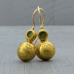 "22k gold dome and green Peridot earrings which not only bring your attire together but are also a stunning statement, look no further than these marvelous 22k solid gold earrings. The backs are secured with 9k gold while the locking French wires are handmade with 14k yellow gold. Earrings Width - 0.43''( 11 mm). Length without the ear wire - 0.7\" (17 mm). Length from top of the ear wire to bottom of the earring - 1.1\" (29 mm). The earrings will be packed in a gift box ready to give as a gift. 22k Gold Gemstone Round Earrings, Gold Domed Gemstone Jewelry, Formal Green 22k Gold Earrings, Elegant Green Hammered Earrings, Elegant Hammered 22k Gold Earrings, Traditional Hammered Yellow Gold Earrings, Silver Bar Bracelet, Dome Earrings, Organic Earrings