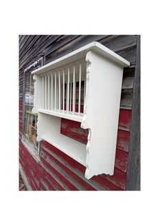 a white shelf sitting on the side of a red building