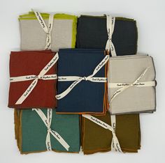 six folded napkins tied together in different colors