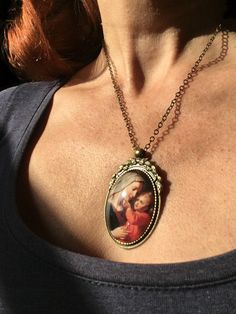 Beautiful pendant of the Virgin Mary and baby Jesus. The pendant is approx. 2,2 x1,6 inch (5,5 x 4 cm) and is set in a leadfree antique brass setting. The necklace is a leadfree antique brass chain (length approx. 42cm). Due to the shape of the glass cabochon the light is reflected, so the real pendant is much more beautiful than the picture. The pendant is delivered in a nice gift pouch. Please follow me on Pinterest and Instagram! Vintage Pendant Jewelry As Gift For Mom, Vintage Necklace For Mother's Day Gift, Vintage Round Pendant Necklace For Mother's Day, Vintage Jewelry For Mother's Day Gift, Vintage Necklaces For Mother's Day Jewelry Making, Vintage Jewelry Gift For Mother's Day, Handmade Vintage Jewelry For Mom, Vintage Mother's Day Jewelry Gift For Her, Vintage Oval Pendant Jewelry For Mother's Day