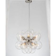 a chandelier hanging from the ceiling in a room with white walls and flooring